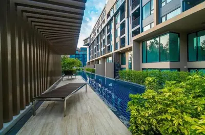 a bench sitting on the side of a building at Modern 1 bedroom in Surin beach in Surin Beach