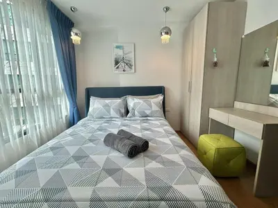 a bedroom with a bed with a gray and white patterned bedspread at Centrio 2 Bedrooms Condos in Town-Central Phuket in Ban Rangeng