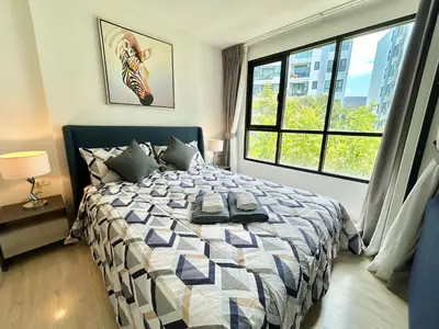 a bedroom with a bed and a large window at 1 Bedroom Condos Close to Shopping Malls in Ban Rangeng