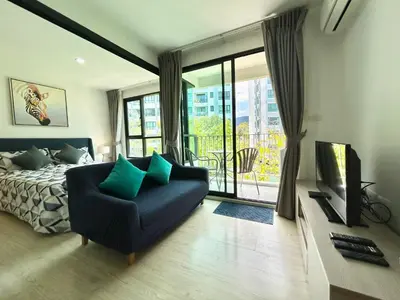 a bedroom with a bed and a couch and a television at 1 Bedroom Condos Close to Shopping Malls in Ban Rangeng