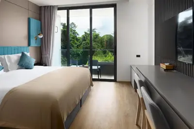 a hotel room with a bed and a large window at Amazing La Green 10 min walk to Layan Beach in Layan Beach