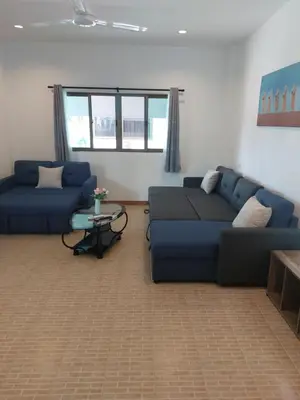 a living room with two blue couches and a table at Smile House Apartment 24 in Karon Beach