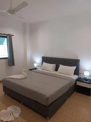 a bedroom with a large bed with two pillows at Smile House Apartment 24 in Karon Beach