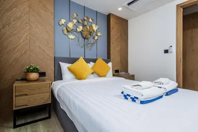a bedroom with a large white bed with yellow pillows at Suite Edena 2BR Pool View 300m to Rawai in Rawai Beach