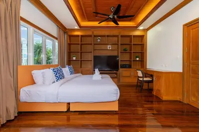 a bedroom with a bed and a flat screen tv at 7BR Grand Pool Villa in heart Patong in Patong Beach
