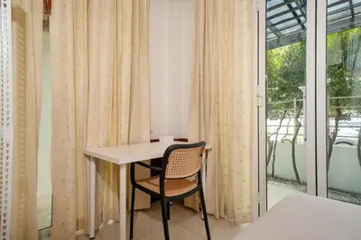 a table and a chair in a room with a window at 7BR Grand Pool Villa in heart Patong in Patong Beach
