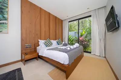 a bedroom with a bed and a large window at Bougainvillea Luxury Pool Villas in Ban Pak Lak