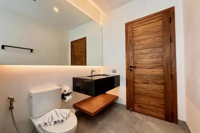 a bathroom with a toilet and a sink at Bougainvillea Luxury Pool Villas in Ban Pak Lak