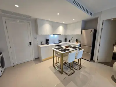 a kitchen with a table and chairs and a refrigerator at Luxury Condo The City Phuket in Heart of Phuket in Kathu