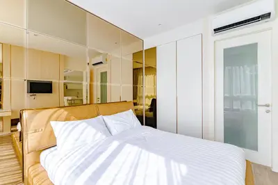a bedroom with a bed with a large mirror at Luxury Condo The City Phuket in Heart of Phuket in Kathu