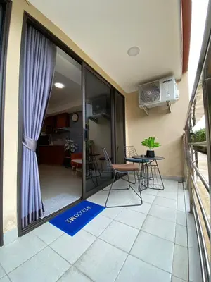 a balcony with a table and chairs and a window at Rawai Beach - 1 BR Cozy Condo in Nai Harn Beach