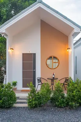a house with a table and chairs in front of it at Sachi Minimal House Bangtao Beach - Near Muay Thai Gym in Surin Beach
