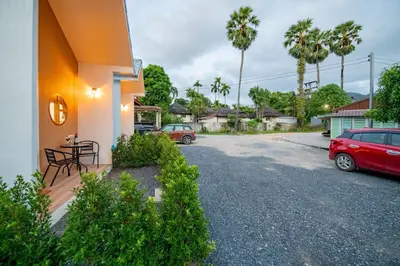 a driveway of a house with a red car parked at Sachi Minimal House Bangtao Beach - Near Muay Thai Gym in Surin Beach