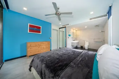 a bedroom with a large bed and a blue wall at Bangtao Beach Garden - 2 BR Apartment in Surin Beach
