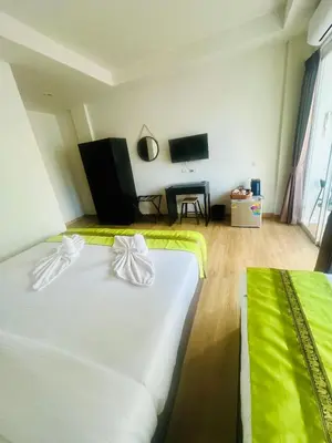 a hotel room with two beds and a flat screen tv at 28 Boutique Hotel - Newly Renovated in Patong Beach