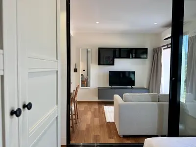 a living room with a couch and a television at 1BR Title Halo at Naiyang beach in Nai Yang Beach