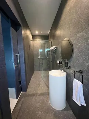 a bathroom with a sink and a shower with a mirror at The Granary Villas by SP in Ban Pak Lak