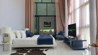 a bedroom with a king sized bed and a television at The Granary Villas by SP in Ban Pak Lak