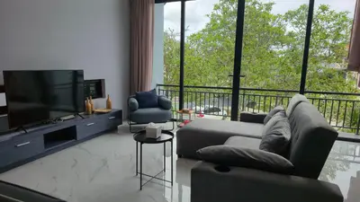 a living room with a couch and a flat screen tv at The Granary Villas by SP in Ban Pak Lak