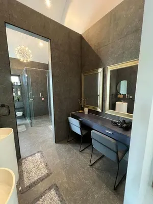 a bathroom with a sink and a vanity with a mirror at The Granary Villas by SP in Ban Pak Lak
