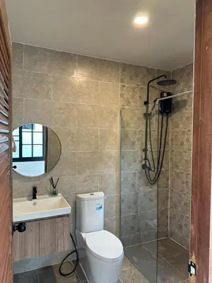 a bathroom with a toilet and a shower and a sink at Chalong Home Phuket in Phuket Town