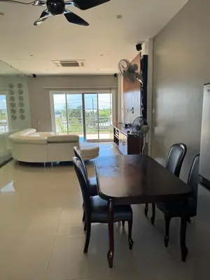 a dining room with a table and chairs and a couch at Rawai Seaview Pool Townhouse in Rawai Beach
