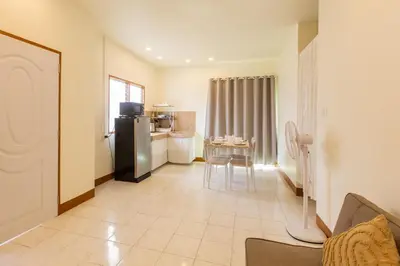 a kitchen with a refrigerator and a table in a room at Homehug in Ban Thalat Choeng Thale