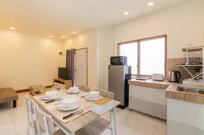 a kitchen and dining room with a table and chairs at Homehug in Ban Thalat Choeng Thale