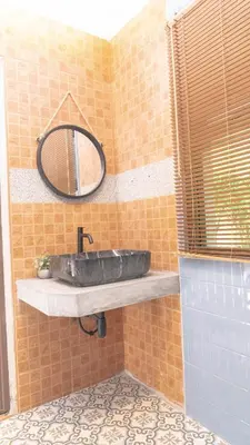 a bathroom with a stone sink and a mirror at Jaokhun Hilltop Patong, Phuket in Patong Beach