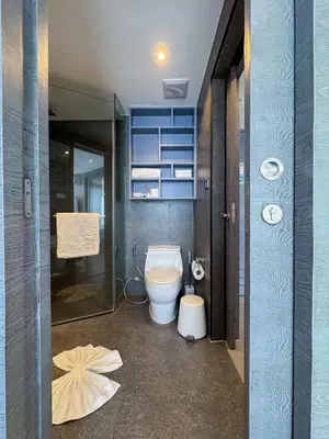 a bathroom with a toilet and a glass door at Amazing 1Bdr Kamala City Gate 3 Pools, Coworking in Kamala Beach
