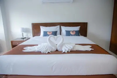 a bed with two white towels on top of it at RQ Phuket Kalim Beach Blue Horizon in Patong Beach