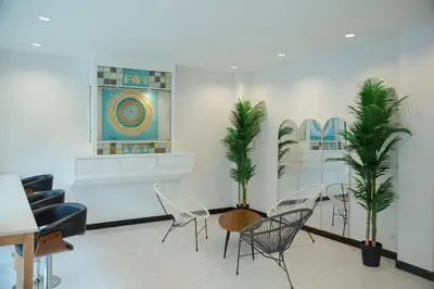 a room with chairs and a table and palm trees at RQ Phuket Kalim Beach Blue Horizon in Patong Beach