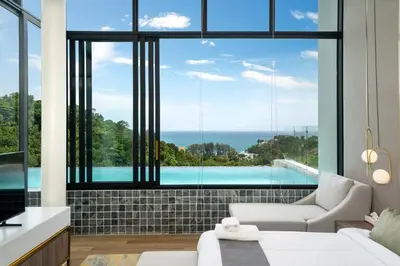 a living room with a view of a swimming pool at The Exclusive Sky D1 \u8c6a\u534e4\u5367\u5ba4\u6d77\u666f\u522b\u5885 \u79c1\u4eba12m\u65e0\u8fb9\u6d77\u666f\u6cf3\u6c60 \u6bcf\u65e5\u6e05\u6d01 in Kamala Beach