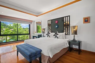 a bedroom with a large white bed with a blue stool at Laguna Village 2 Bedroom Pool View Villa by Banyan Living in Layan Beach