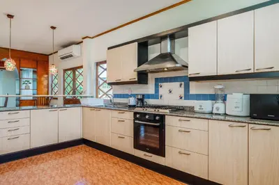 a kitchen with white cabinets and a stove top oven at Tranquility Haven Villa, Kata Beach in Kata Beach