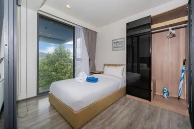 a bedroom with a bed and a large window at Holiday apartment at The Deck by Lofty in Patong Beach