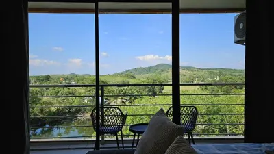a room with a large window with chairs and a table at Квартира in Ban Mai Salae
