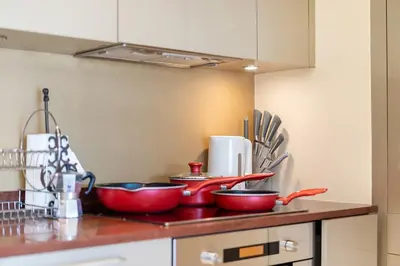 a kitchen counter with three red bowls and utensils at Stylish Thai 2BR Condo Pool & Golf with Balcony in Laguna Phuket