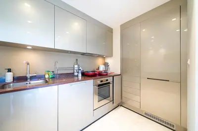a kitchen with white cabinets and a sink at Stylish Thai 2BR Condo Pool & Golf with Balcony in Laguna Phuket