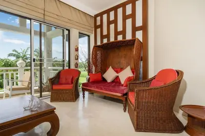 a living room with chairs and a red couch at Stylish Thai 2BR Condo Pool & Golf with Balcony in Laguna Phuket