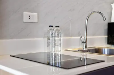 two water bottles sitting on a counter next to a sink at Stylish Forest View Studio Near Naithon Beach 1528 in Nai Thon Beach