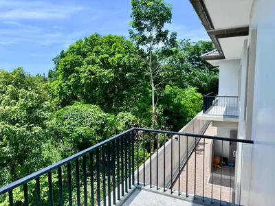 a balcony of a house with trees in the background at Bay Sand Villa by Jai House Phuket in Ban Klang