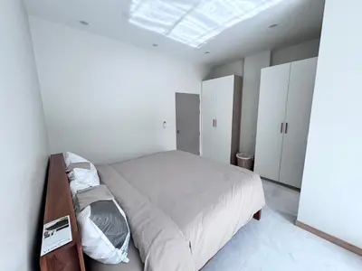 a white bedroom with a bed and a skylight at Bay Sand Villa by Jai House Phuket in Ban Klang