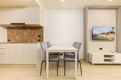 a dining room with a white table and chairs at Suite Luna Pool and Gym Access The Ozone Condo in Bang Tao Beach