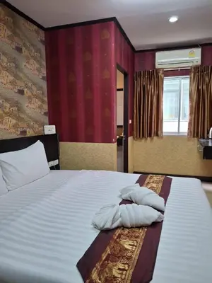 a bedroom with a bed with two pillows on it at Sereneburi Patong Hotel in Patong Beach