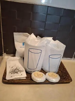 a tray with towels and two cups on a counter at Sereneburi Patong Hotel in Patong Beach