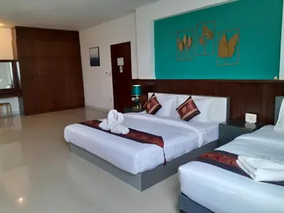 a hotel room with two beds with towels on them at Sereneburi Patong Hotel in Patong Beach
