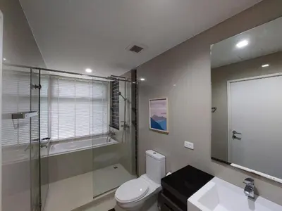 a bathroom with a toilet and a shower and a sink at The Deck Patong in Patong Beach