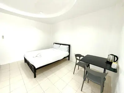 a small bedroom with a bed and a table at Patong Canal Villa 108 in Patong Beach