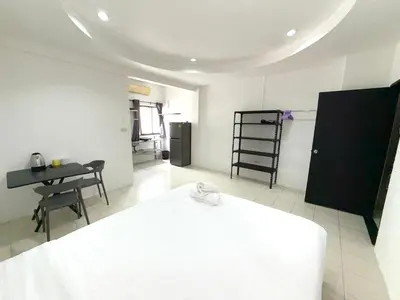 a bedroom with a bed and a table and a desk at Patong Canal Villa 108 in Patong Beach